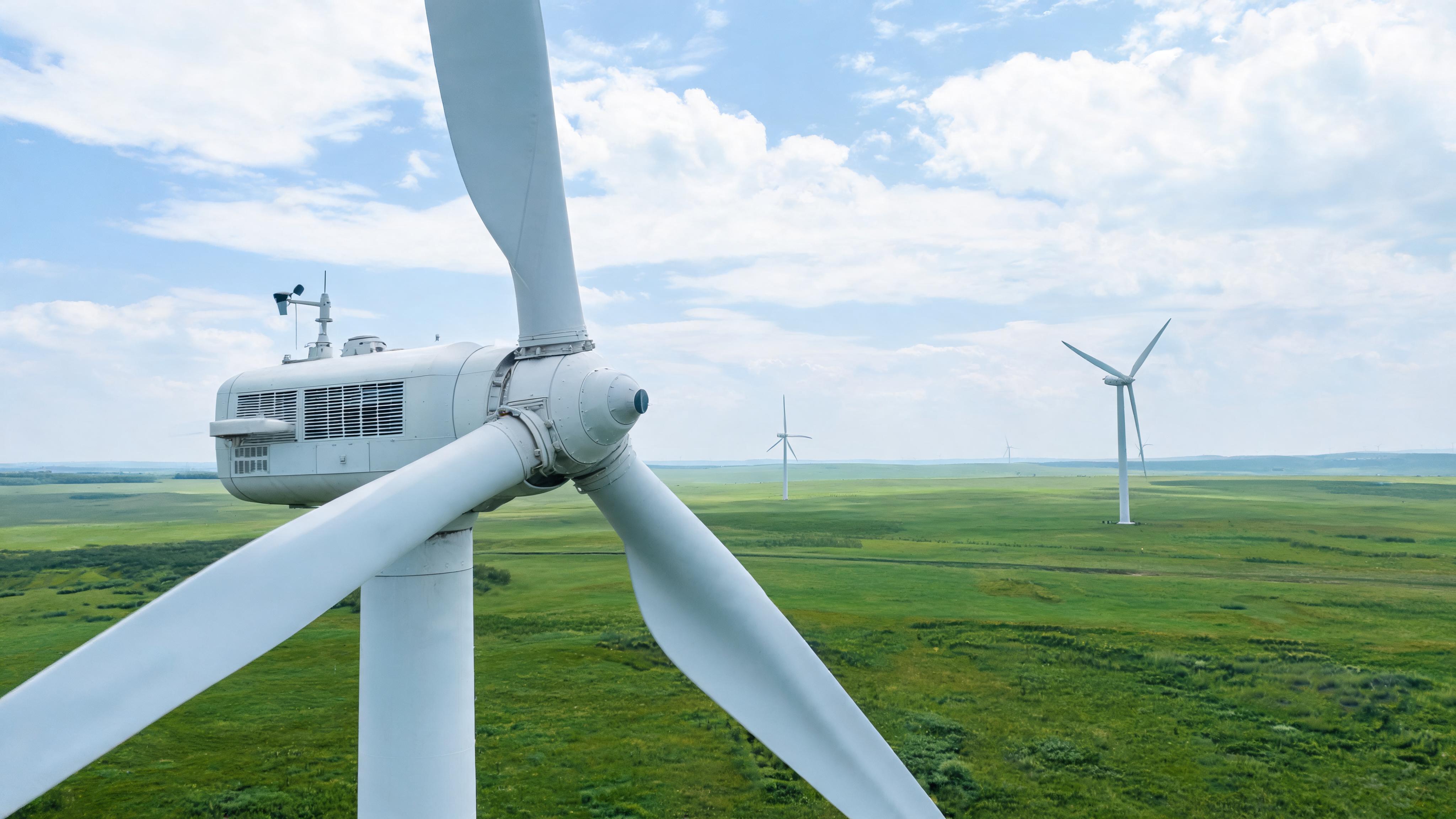 A wind turbine against a sky backdrop, with a focus on its technical housing, no text